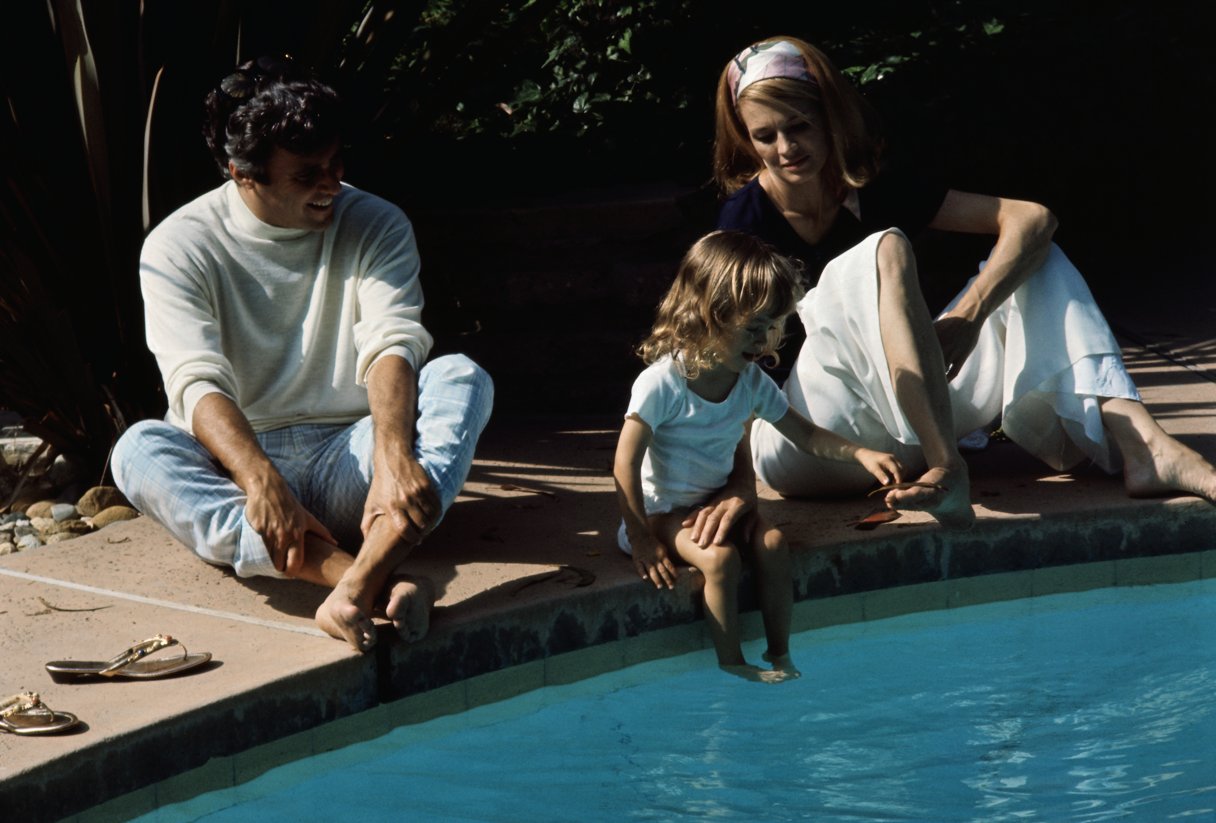 Burt Bacharach, Angie Dickinson, and their daughter Nikki Bacharach photographed by the swimming pool of their Hollywood home on June 3, 1969. | Source: Getty Images