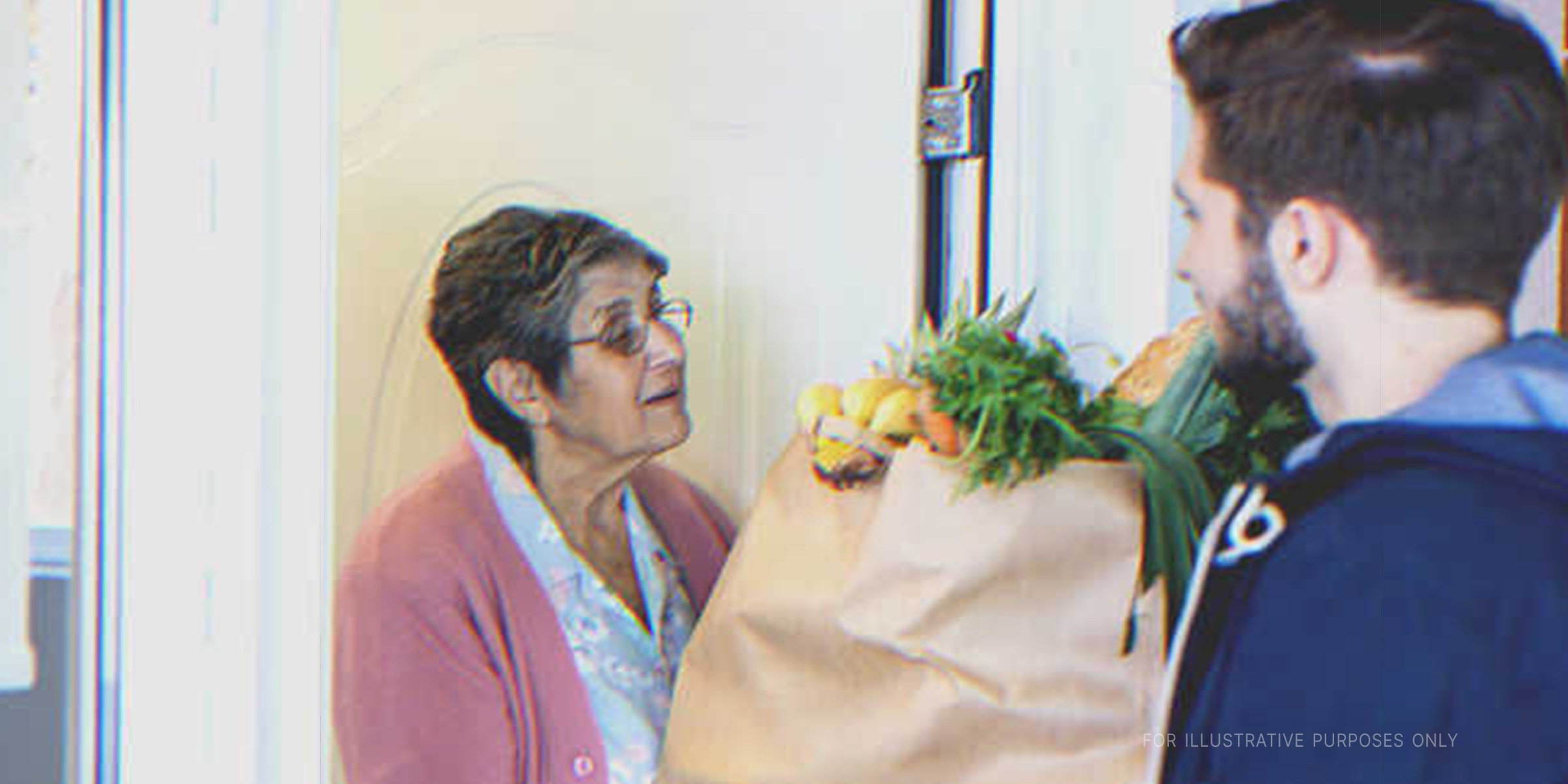 Eine alte Frau nimmt eine Tüte entgegen | Quelle: Getty Images