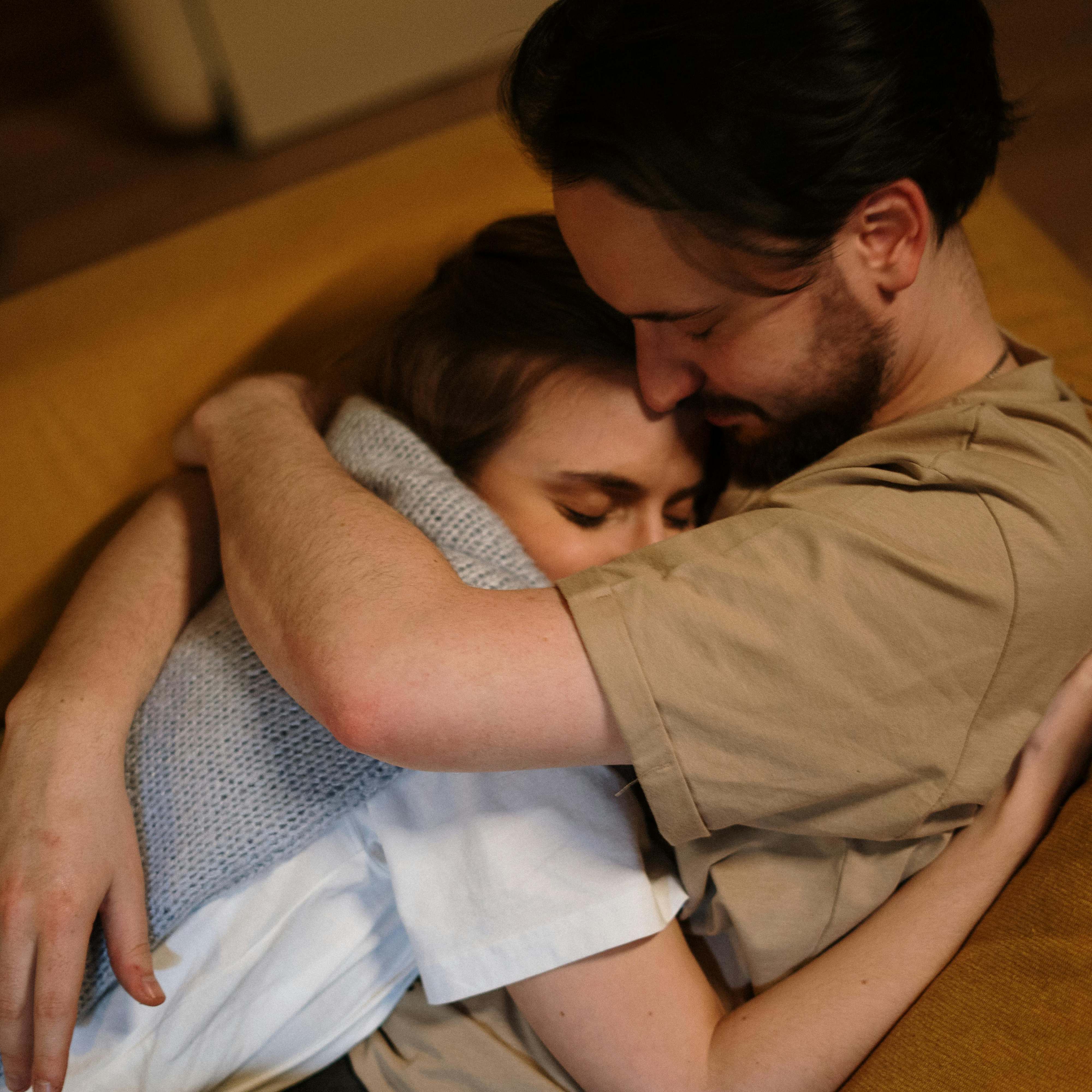 A man comforting a woman on a couch | Source: Pexels