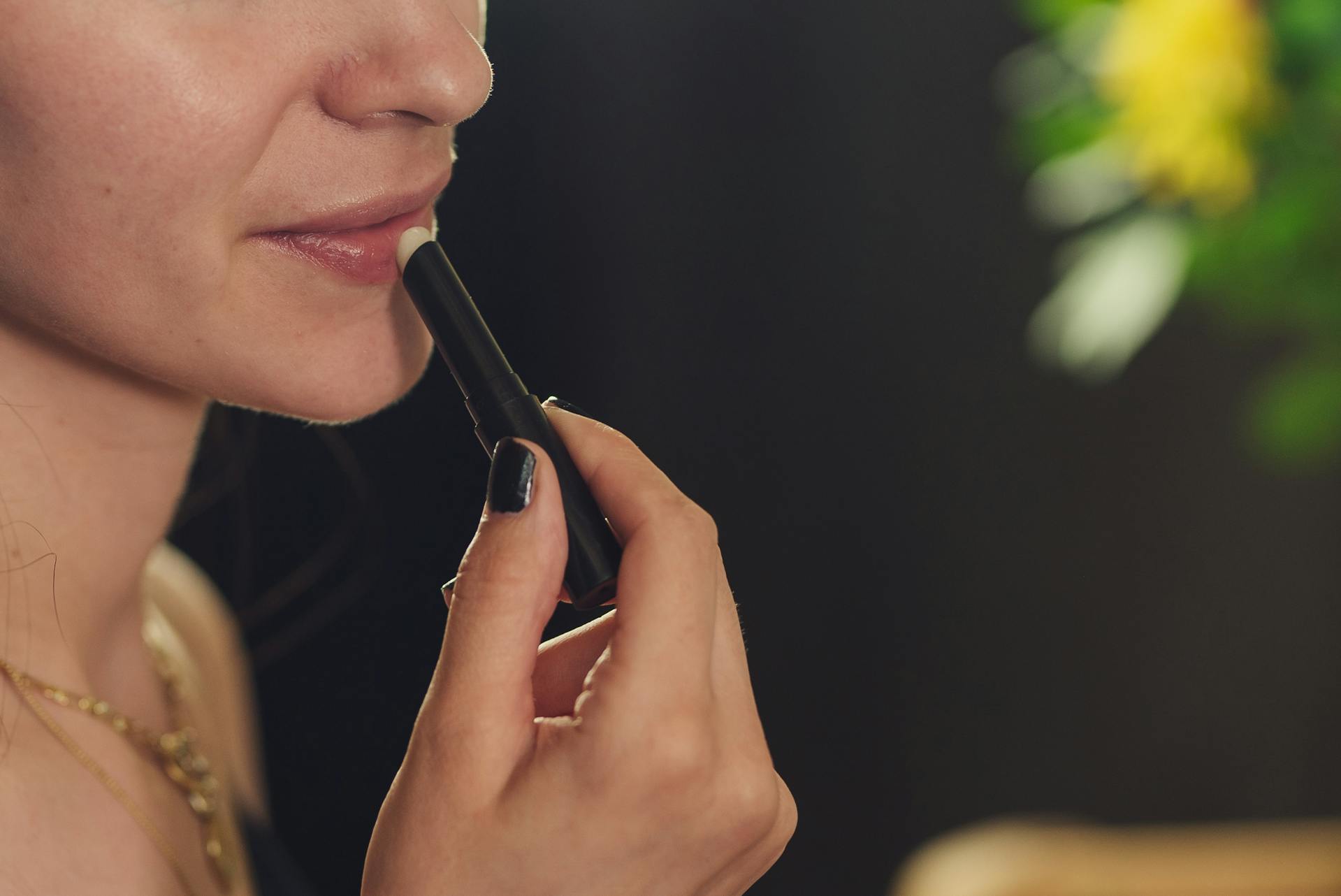 A closeup of a woman applying lipstick | Source: Pexels