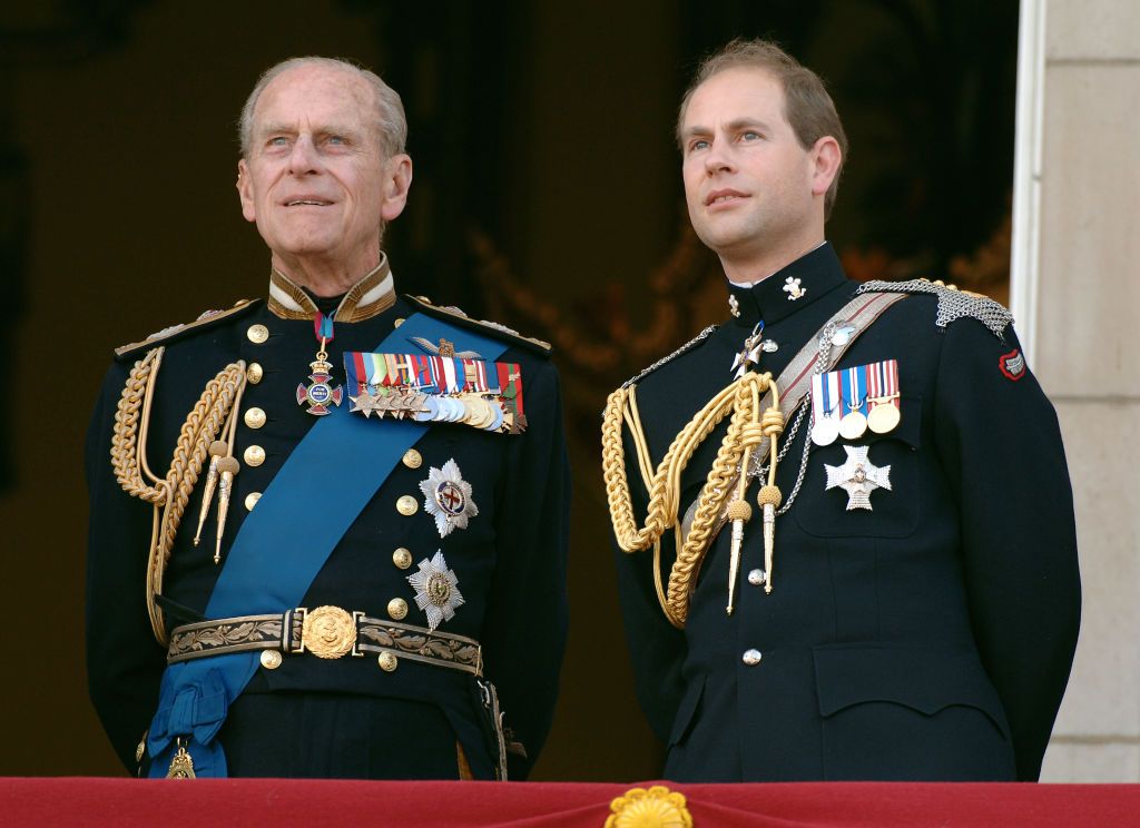 Prince Edward, Earl of Wessex and his father, Prince Philp, Duke of Edinburgh watching the flypast over the Mall of British and US World War II aircraft from Buckingham Palace on National Commemoration Day in London, England | Photo: Anwar Hussein/Getty Images