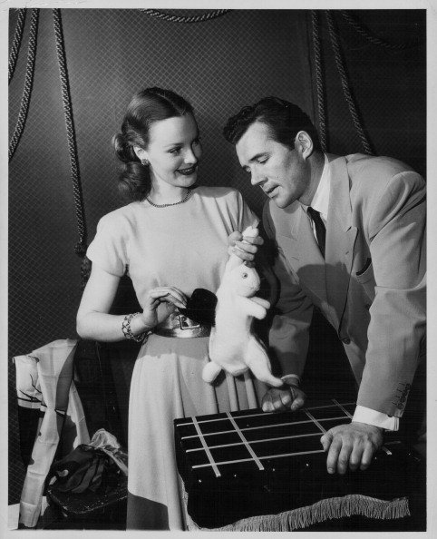 Dorothy Hart and Howard Duff, practicing a magic trick with a rabbit and a hat, circa 1945. | Source: Getty Images.