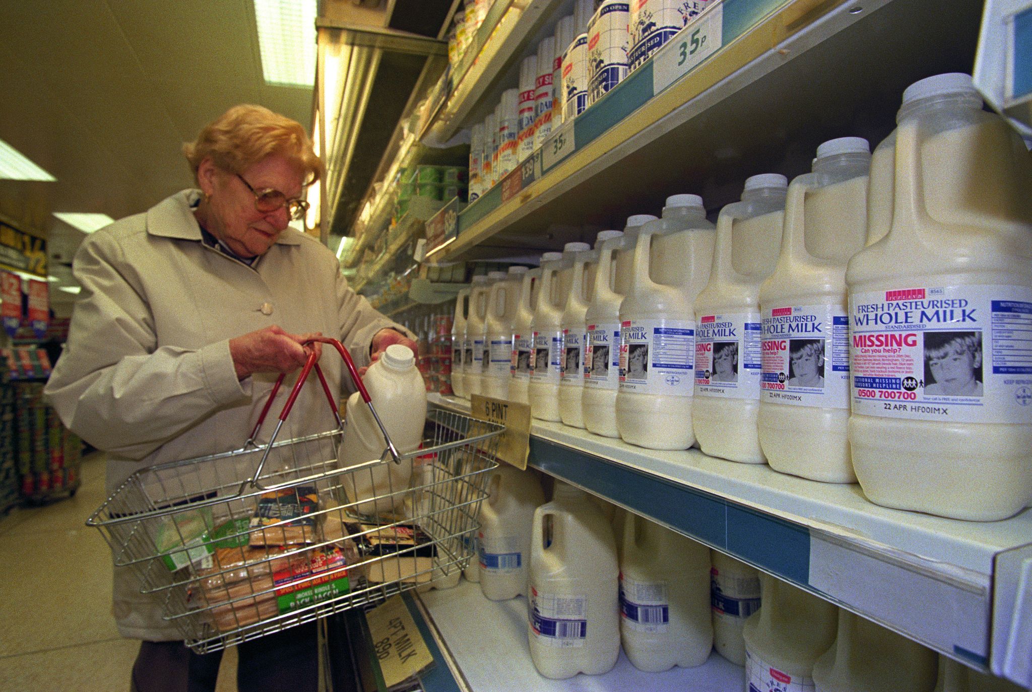 A shopper in Iceland buying a 4 pint milk carton which displays a picture of missing children | Source: Getty Images
