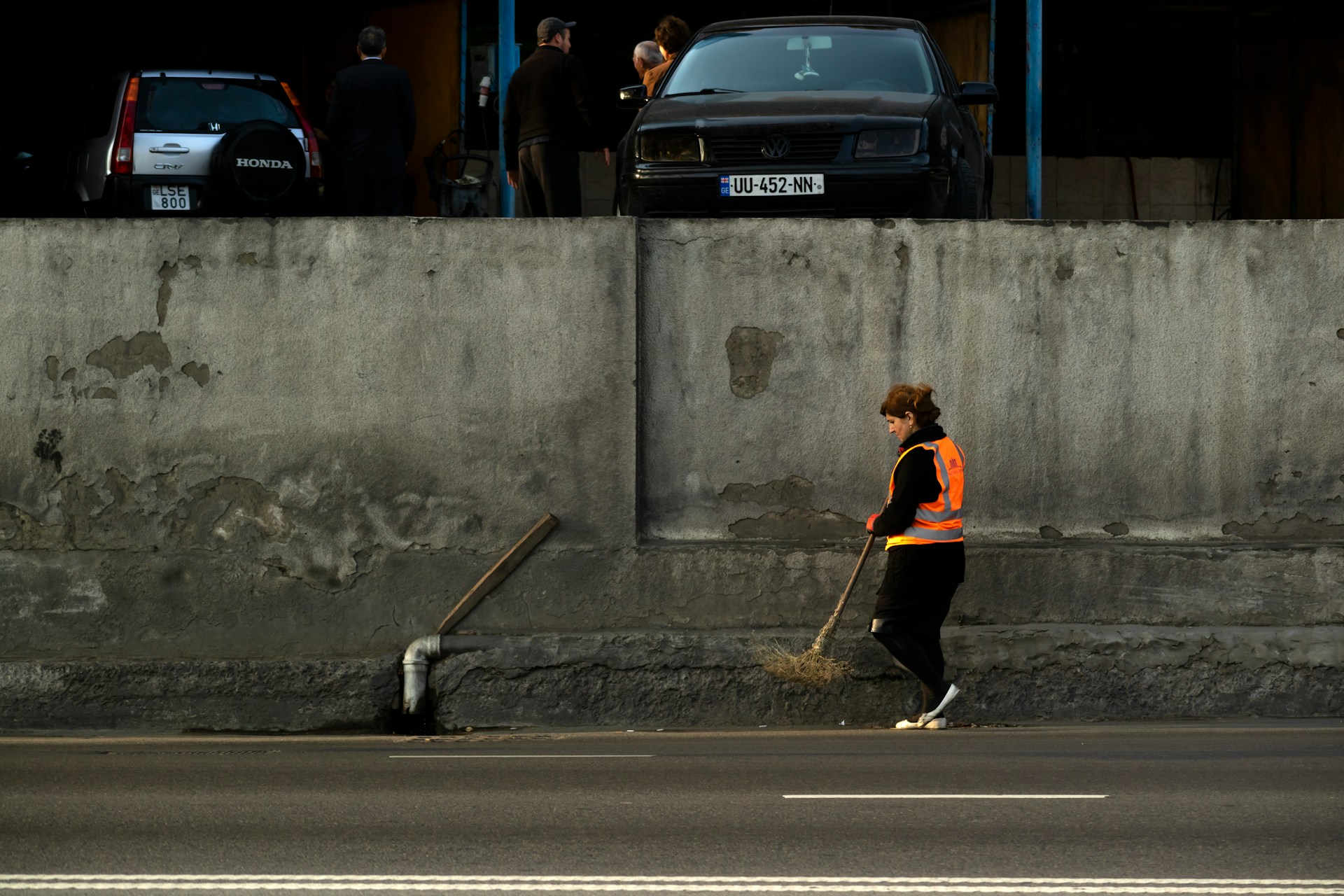 A woman sweeping the road | Source: Unsplash