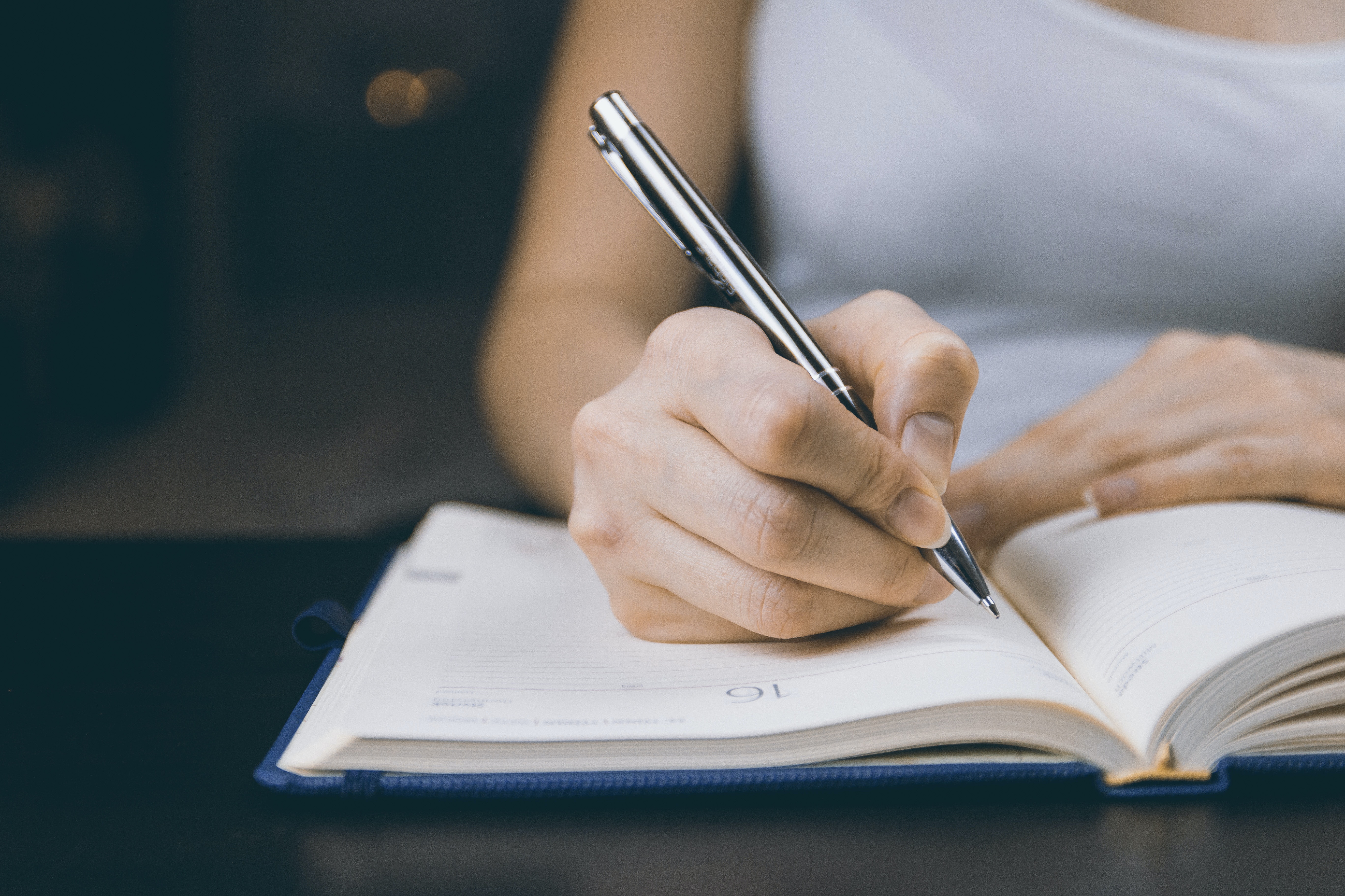 Close up of a woman writing on a notebook  | Source: Pexels