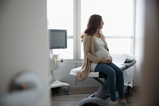 Pregnant woman waiting in clinic examination room | Photo: Getty Images