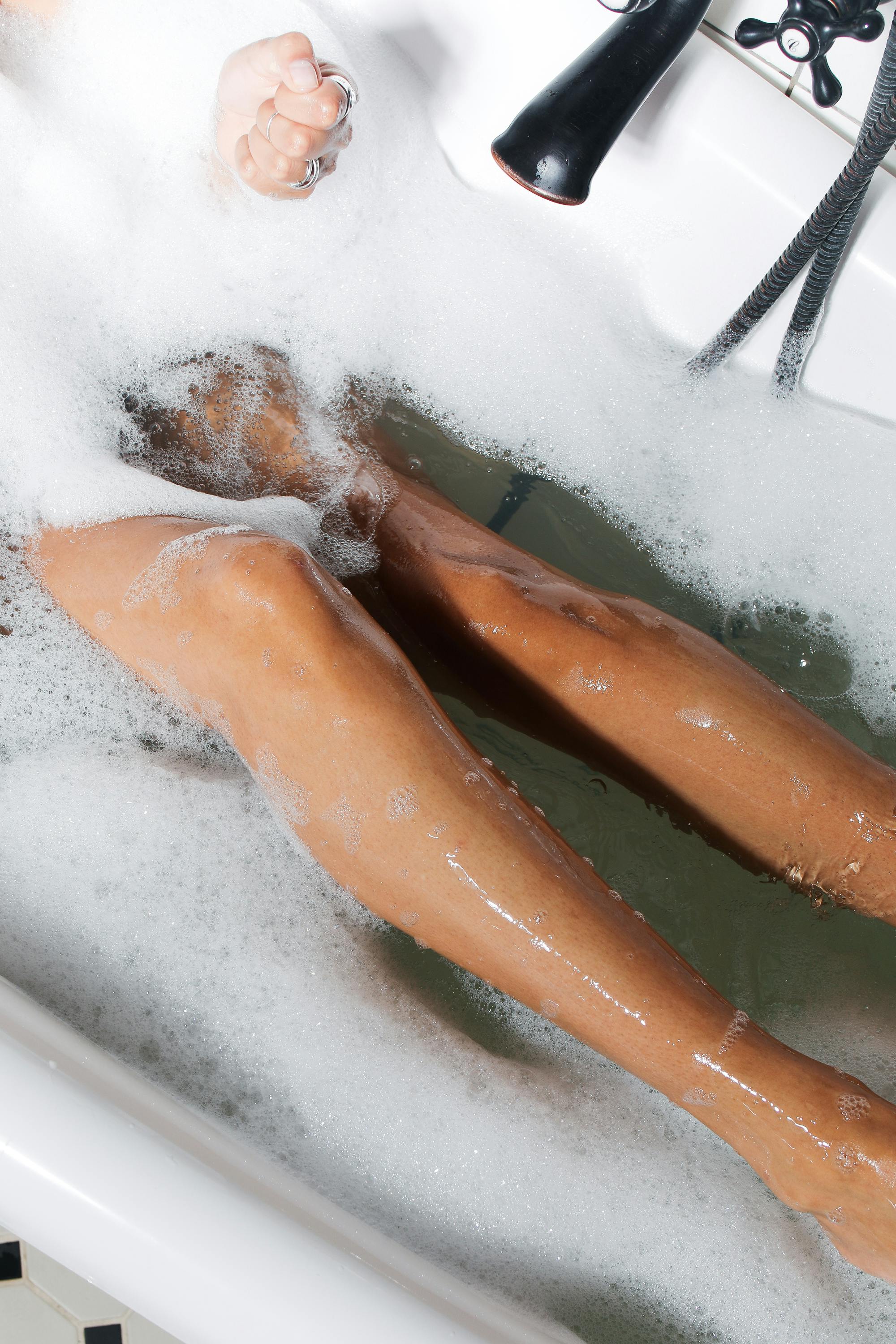 A person relaxes in a bubble bath. | Source: Pexels