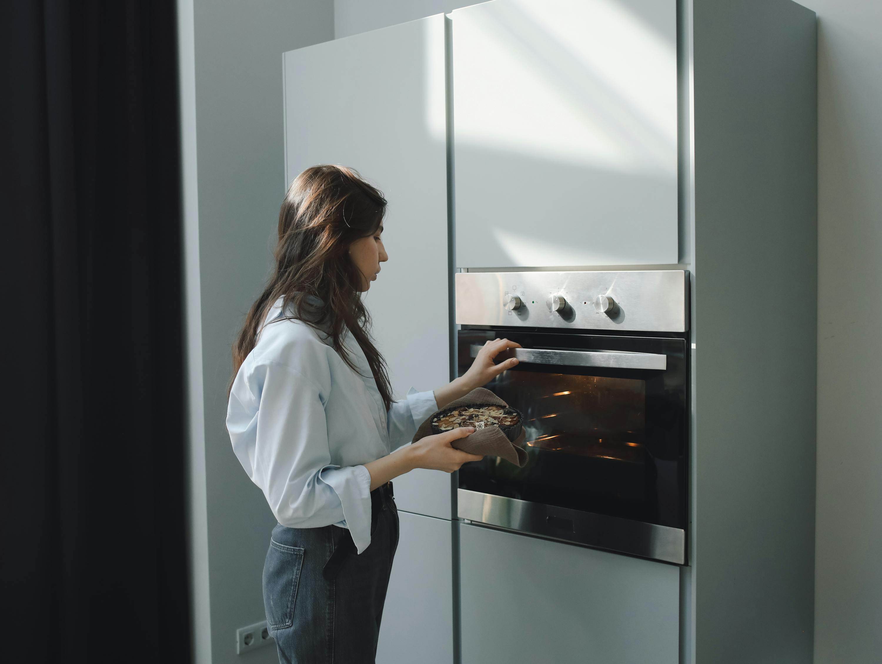 A woman operating her oven | Source: Pexels
