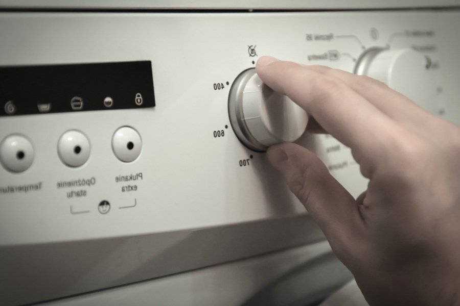 Persona manejando los controles de una lavadora. | Foto: Pixnio