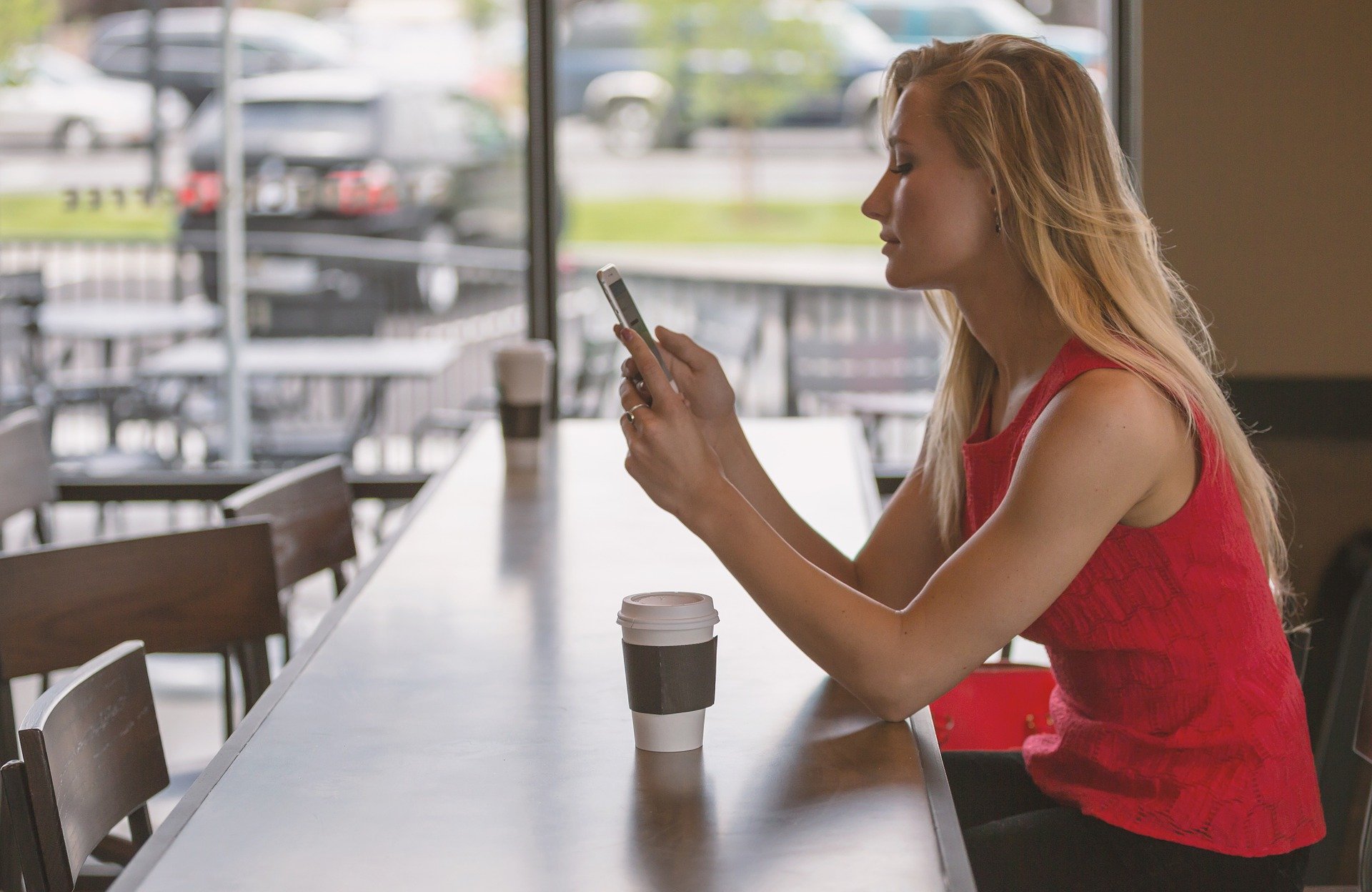 A young woman busy on her cellphone. | Photo: Pixabay.