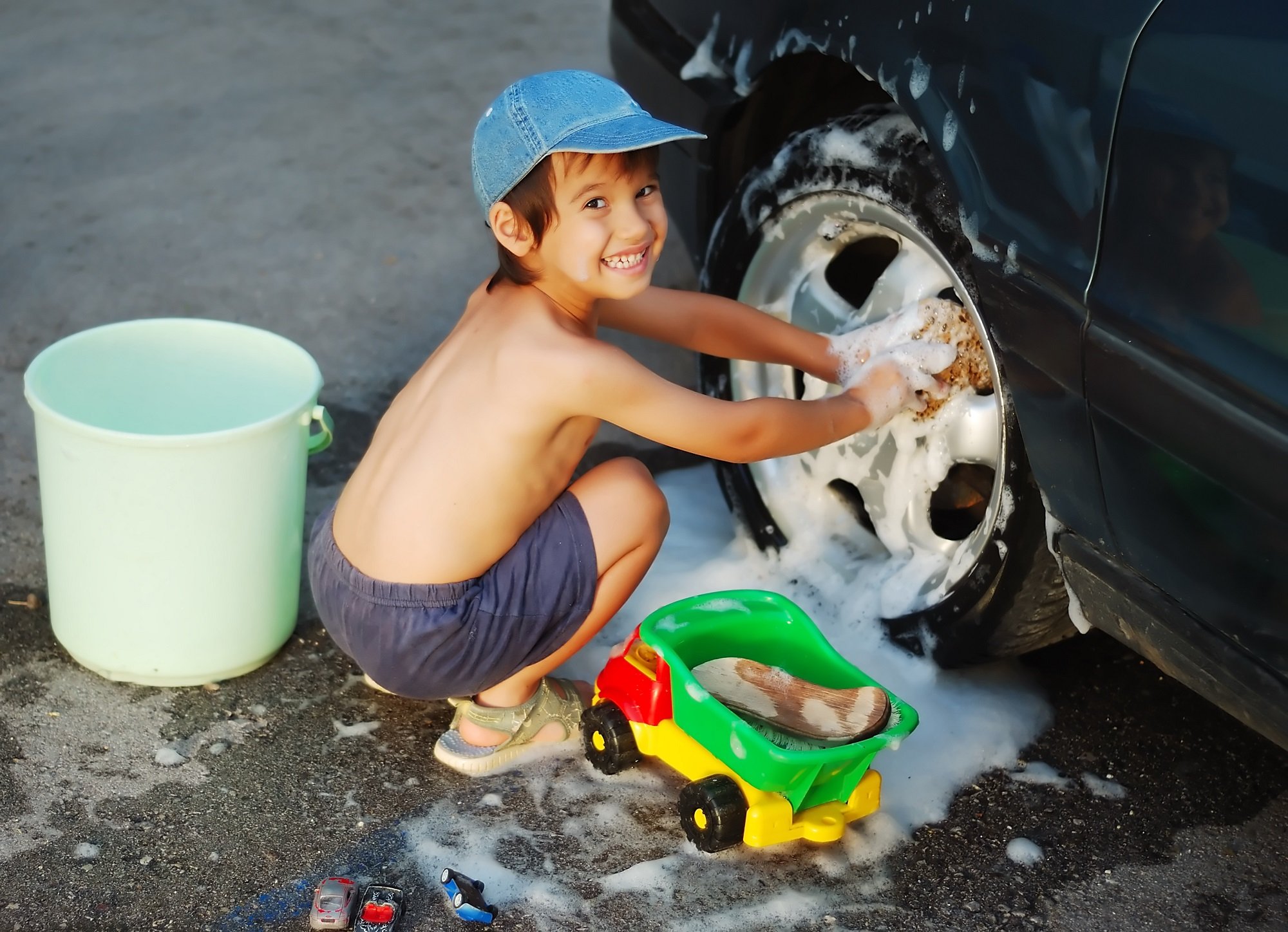 Jovencito ayuda a lavar el auto familiar. | Foto: Shutterstock