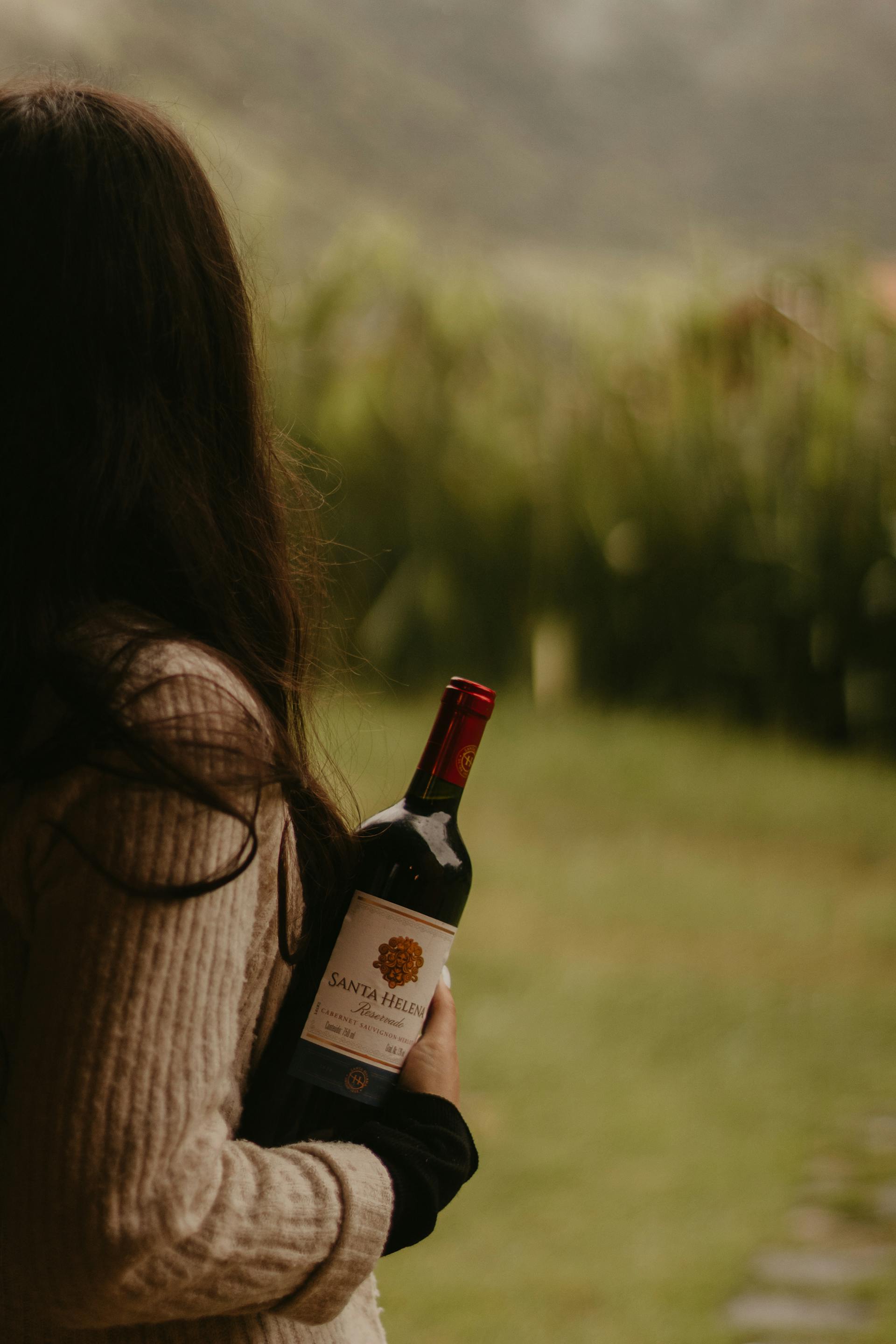 A woman holding a bottle of wine | Source: Pexels