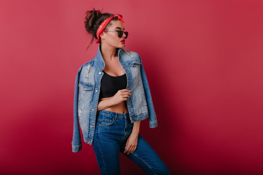 Mujer vistiendo pantalones de jean con top deportivo y chaqueta de jean. | Foto: Shutterstock