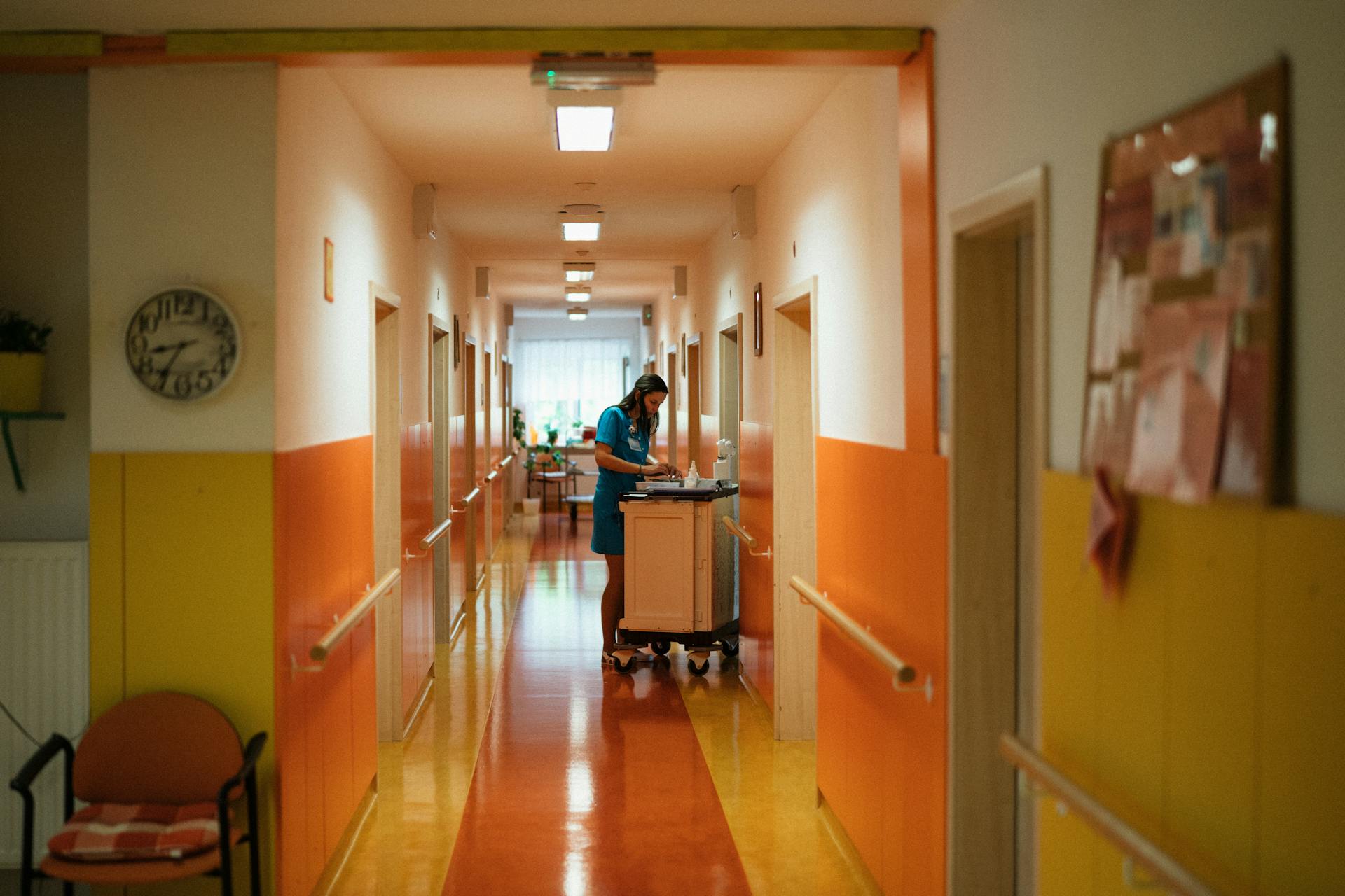 A nurse wheeling a cart in the hospital corridor | Source: Pexels