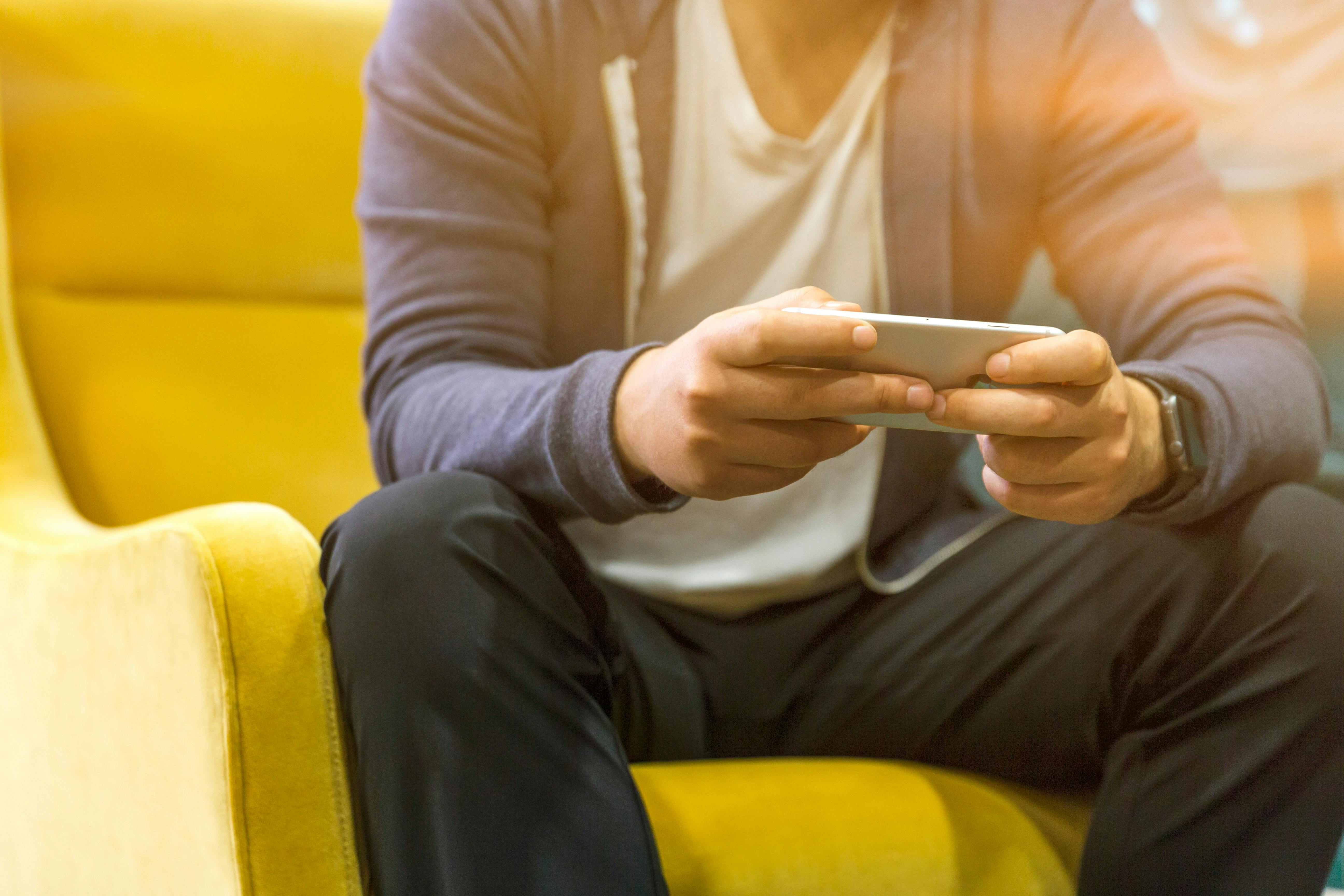 A man sitting, focussed on his mobile phone | Source: Pexels