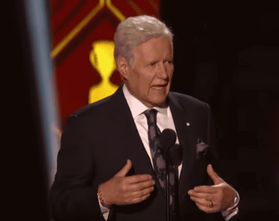 Alex Trebek presenting an award on stage at the NFL Awards.| Photo: YouTube/ NFL.