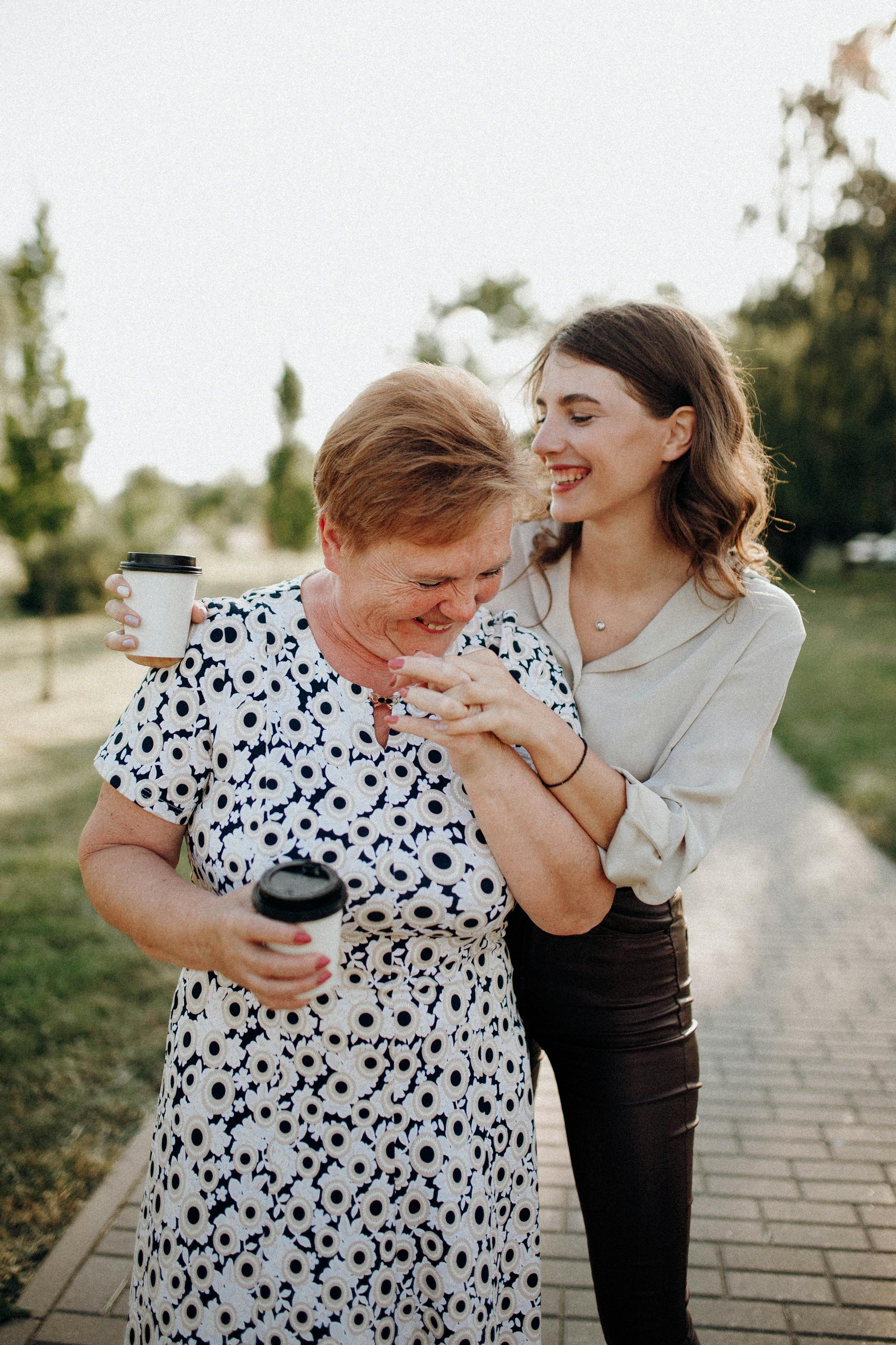 A happy mother-daughter duo holding coffee cups | Source: Pexels