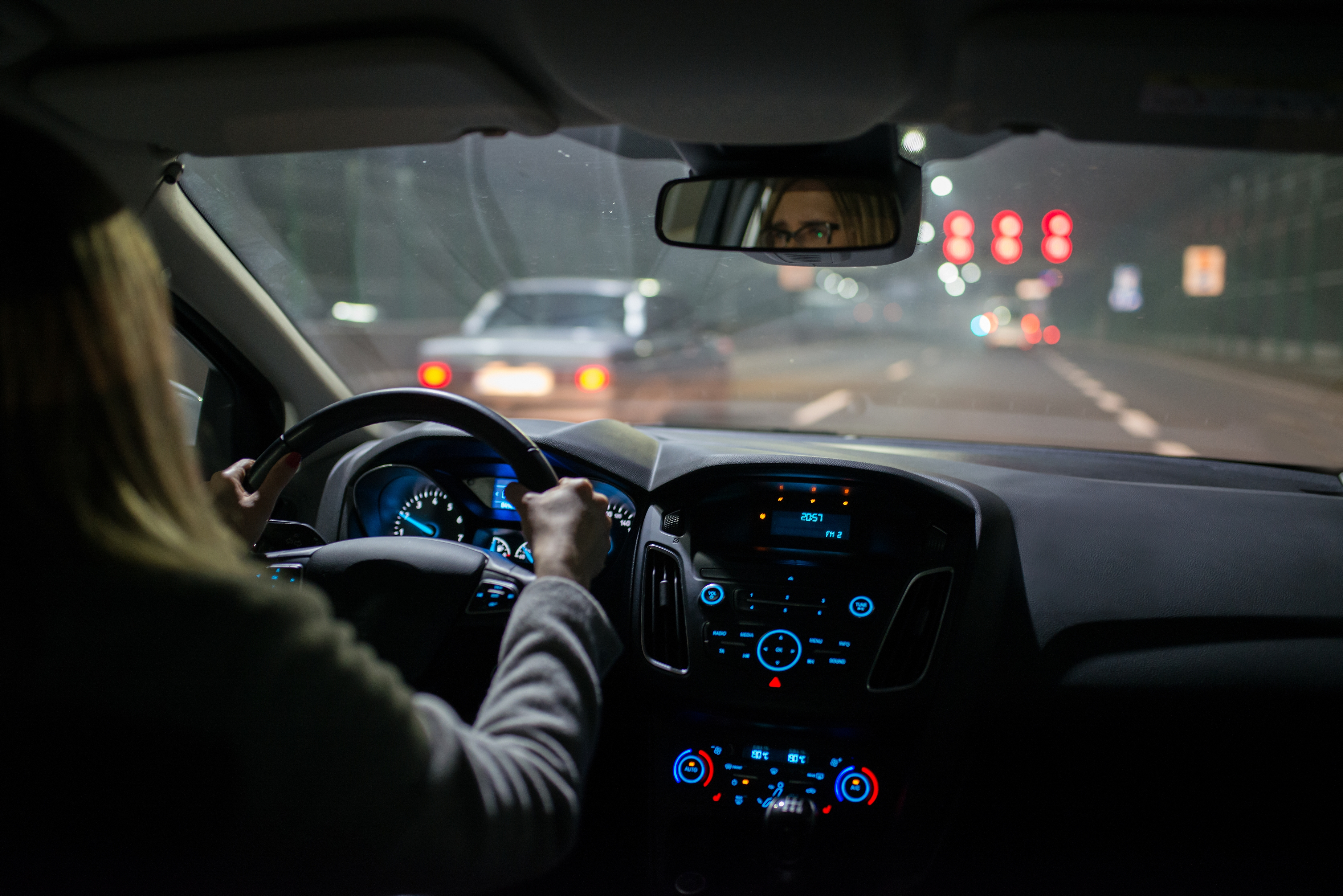 Young woman driving a car at night. | Source: Shutterstock