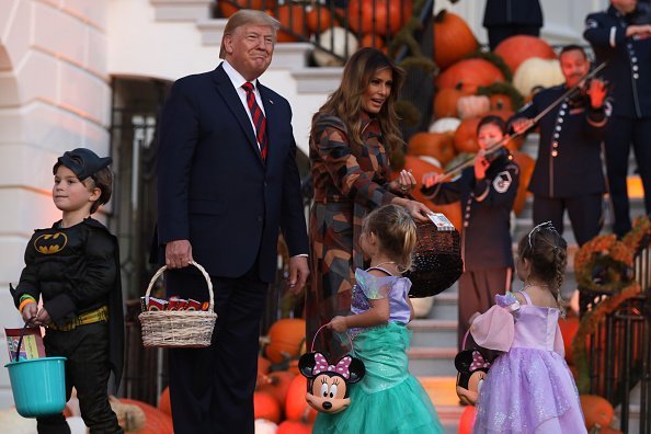President Donald Trump and first lady Melania Trump hand out candy to trick-or-treaters during a Halloween at the White House event at the South Portico of the White House. | Photo: Getty Images