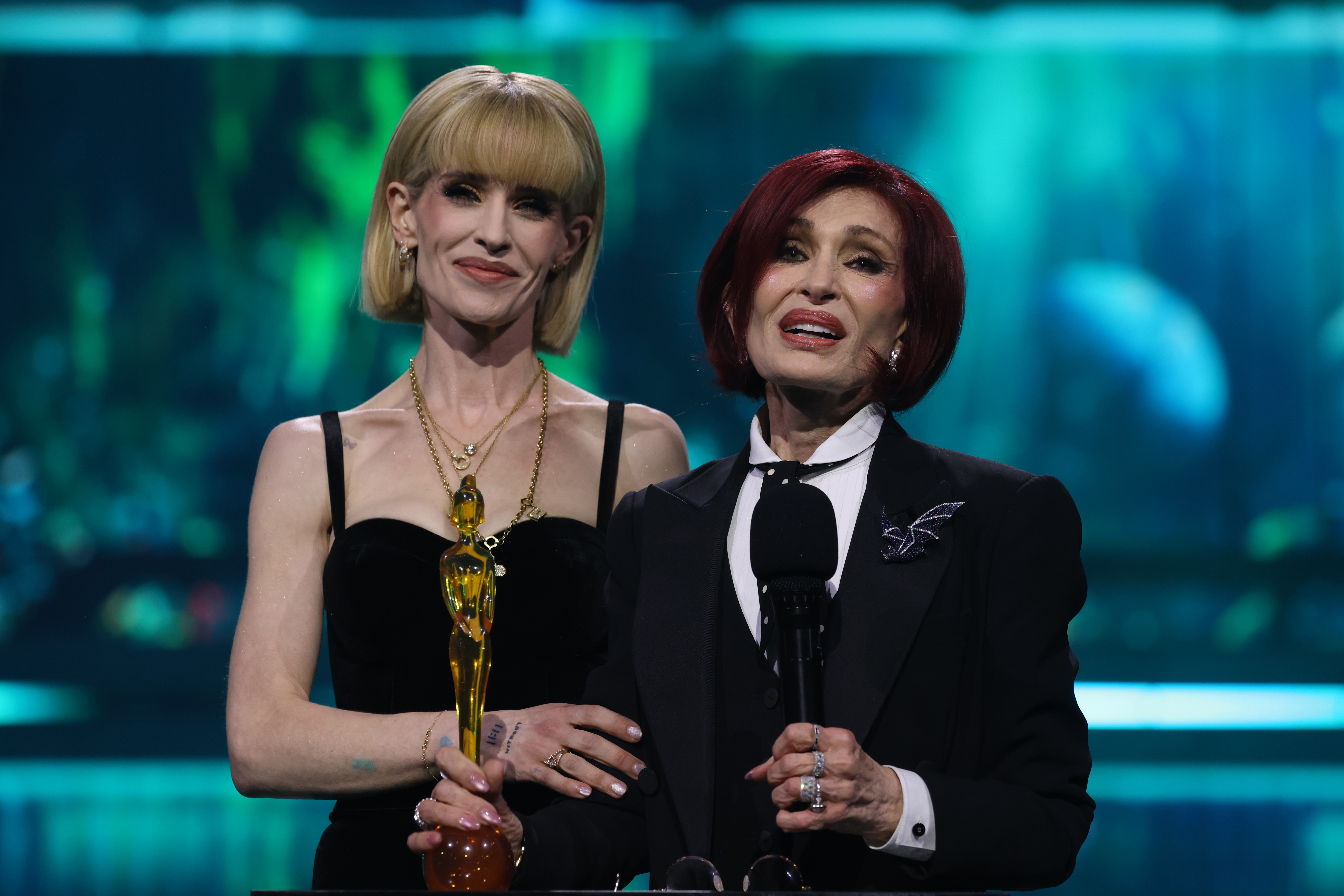 Kelly and Sharon Osbourne accept the Lifetime Achievement award on behalf of the late Ozzy Osbourne on stage during The BRIT Awards 2026 at Co-op Live on 28 February 2026 in Manchester, England. | Source: Getty Images