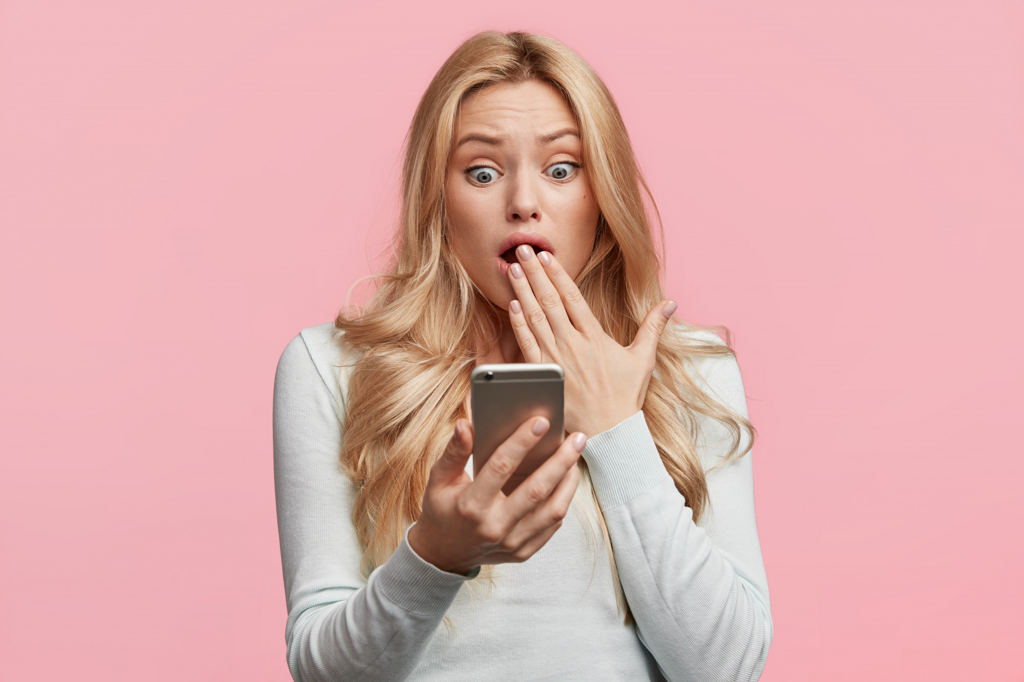 A shocked woman reacting to something on her phone | Source: Freepik