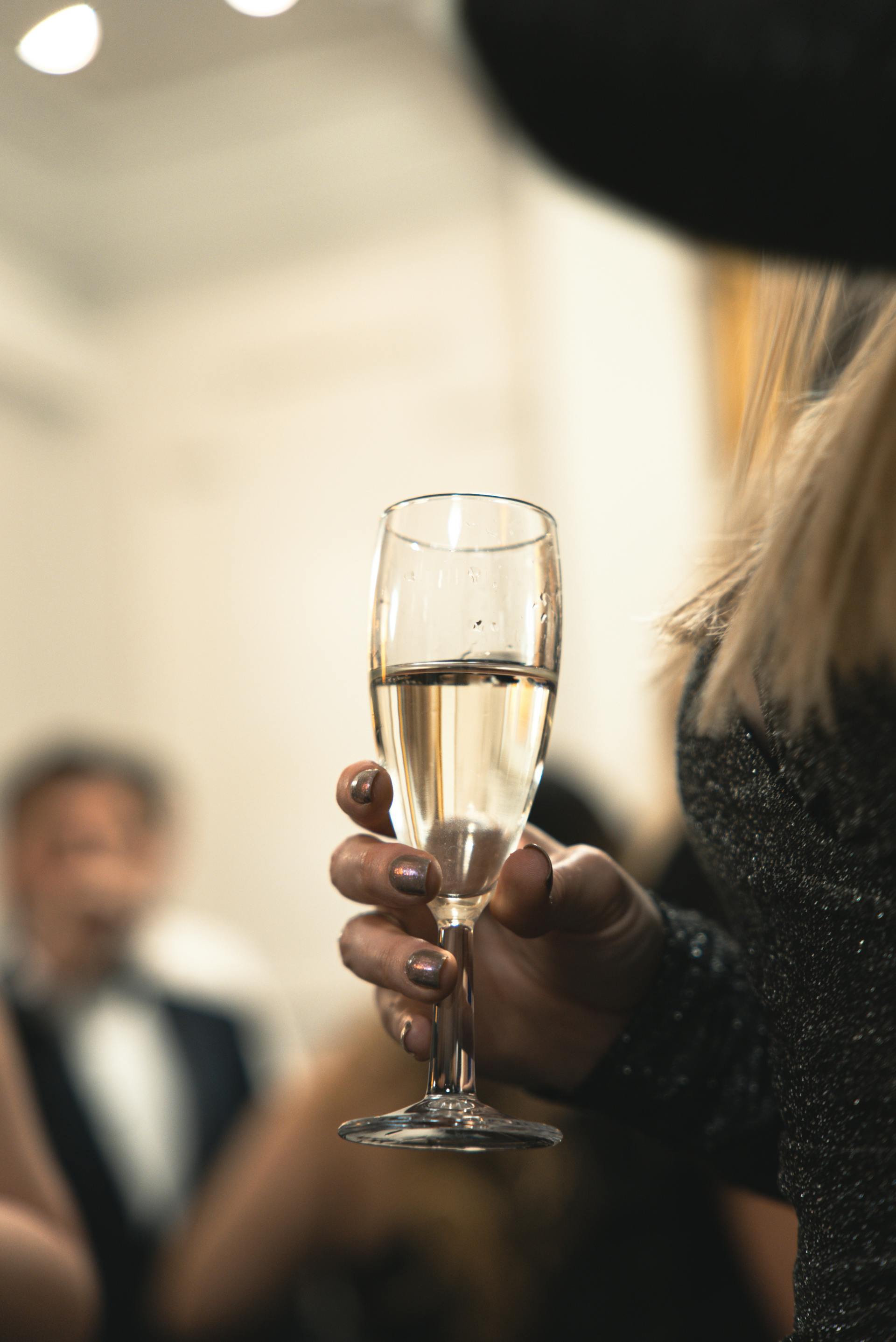 A woman holding a glass of champagne | Source: Pexels