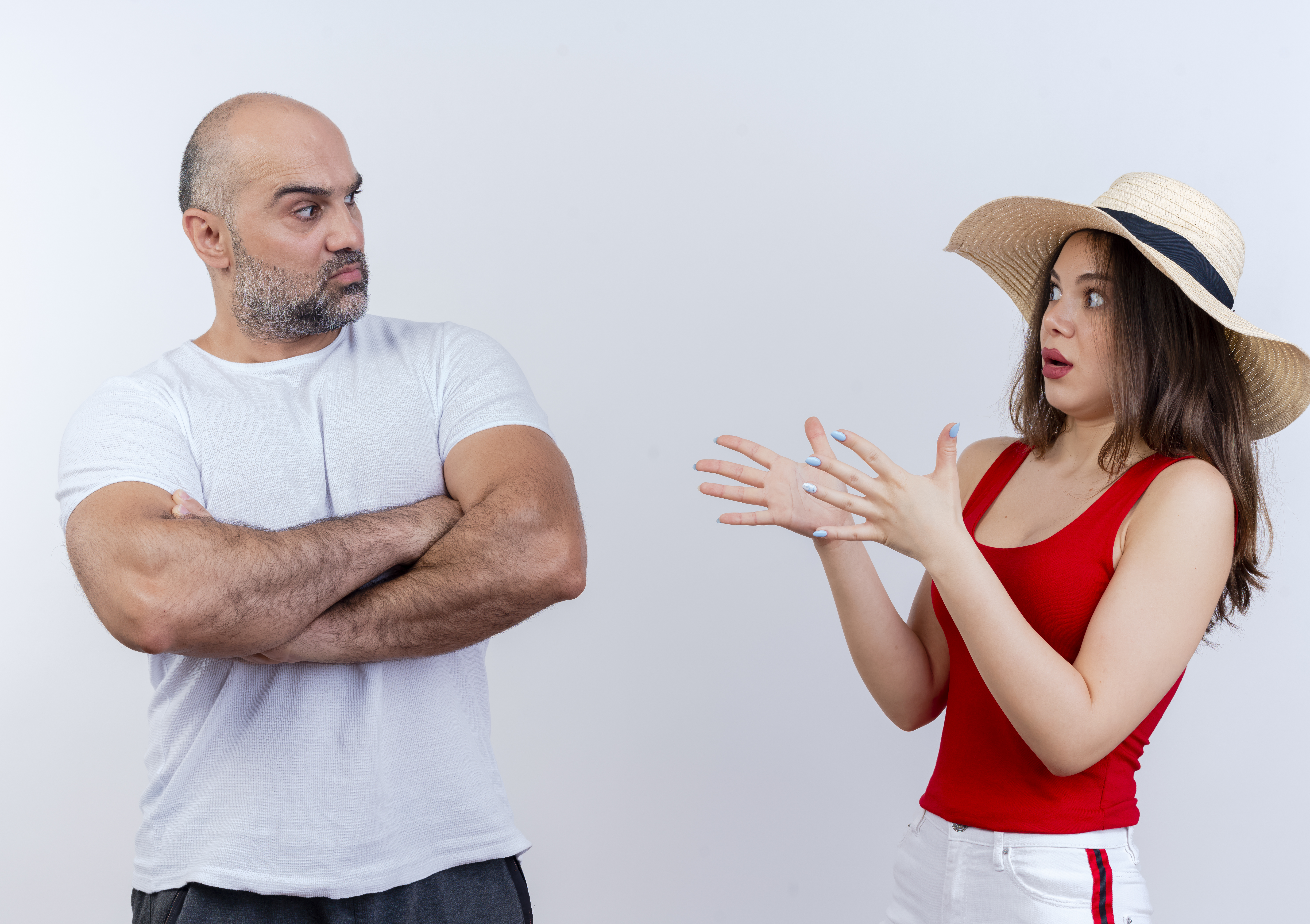 Man showing disapproval to a woman wearing a red top and a hat | Source: Freepik