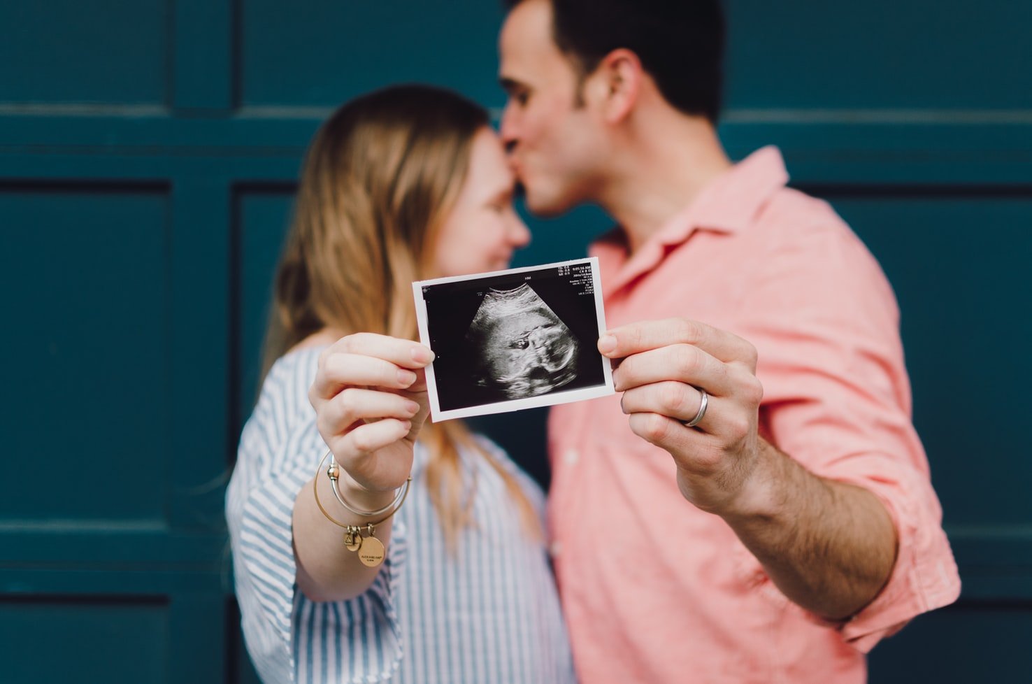 Una pareja muestra la foto de la primera ecografía de su bebé. | Foto: Unsplash