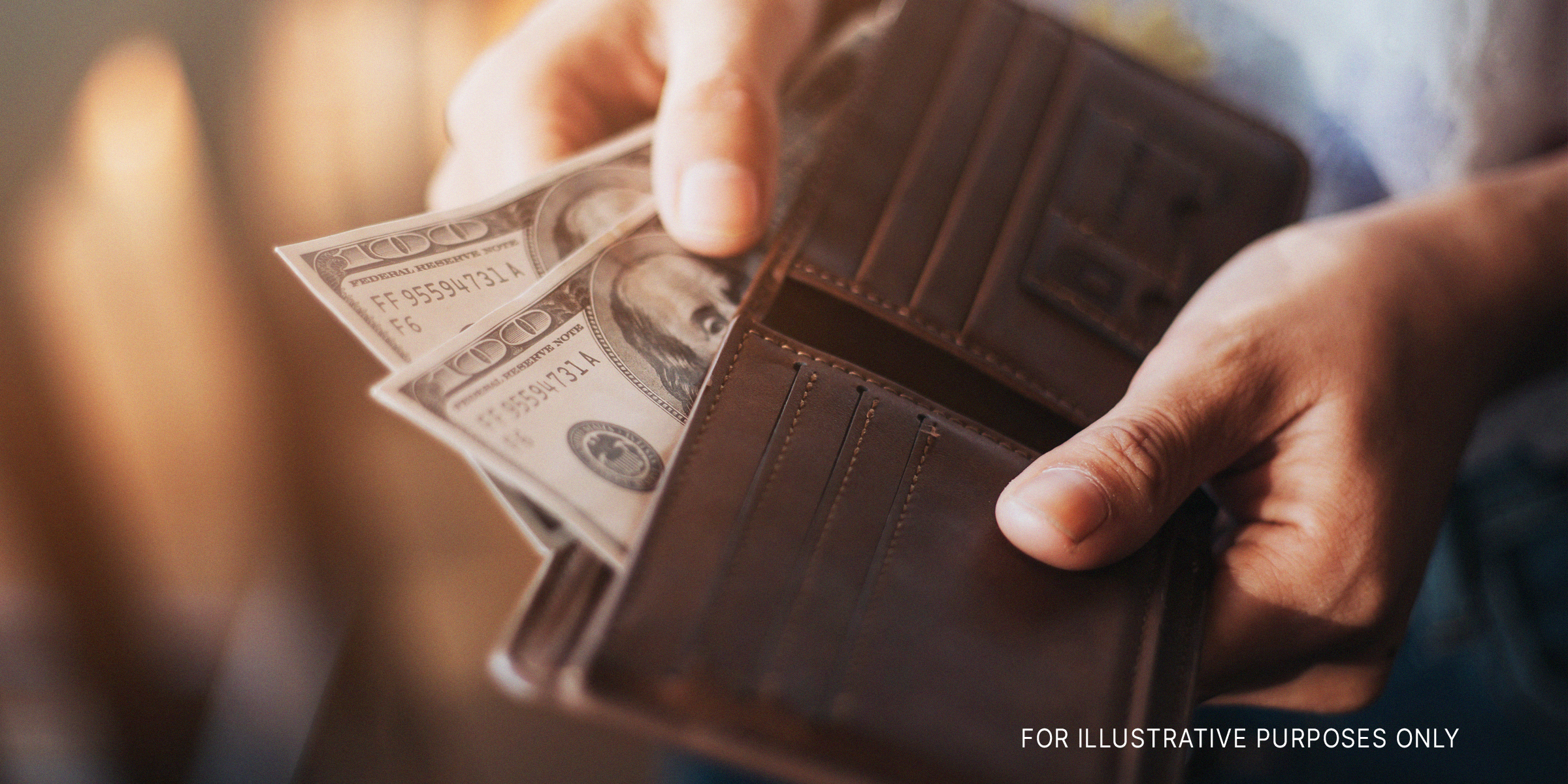 Man holds a brown wallet | Shutterstock