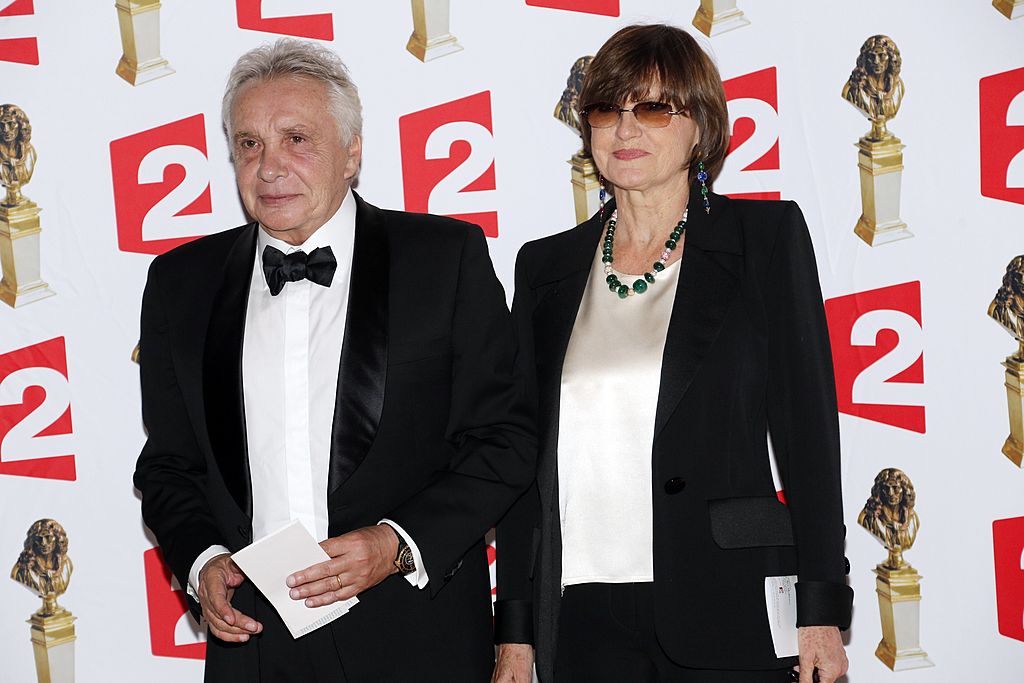Michel Sardou et son épouse Anne-Marie Perier posent à leur arrivée pour assister à la 26e cérémonie de remise des prix du théâtre Molières le 2 juin 2014 au théâtre des Folies Bergère à Paris. | Photo : Getty Images