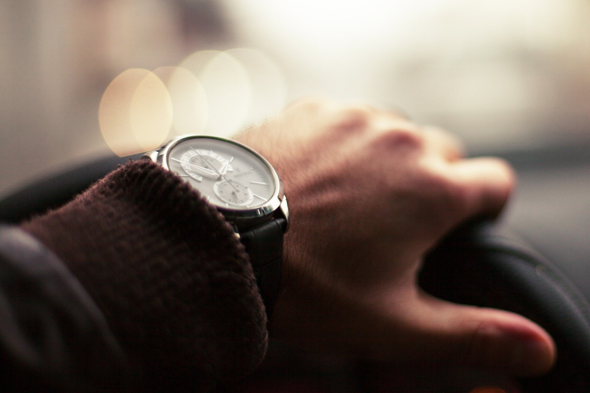 La main d'un homme avec une montre au volant. | Photo : Pixabay