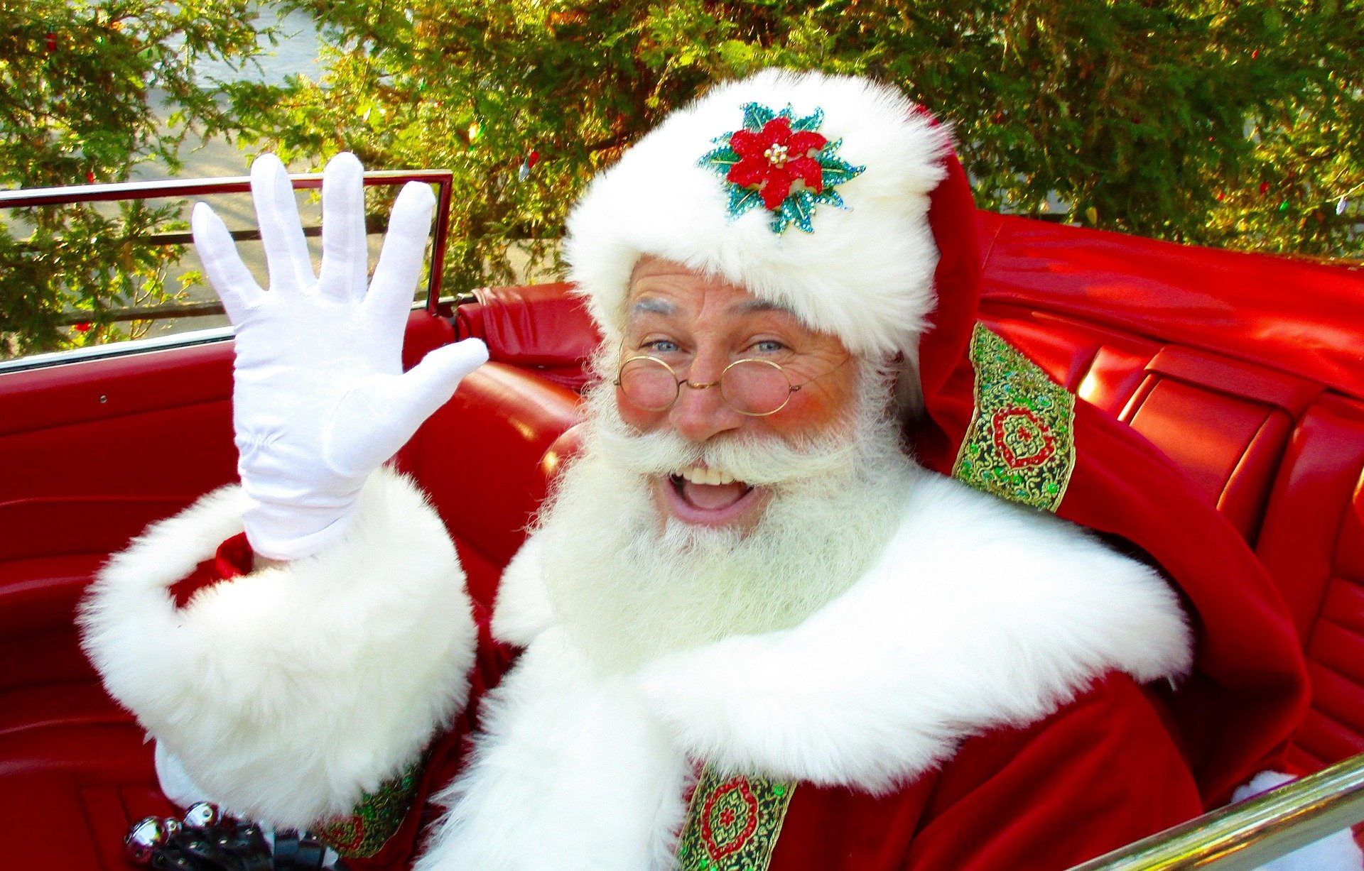 Santa Clause waving as he delivers presents in his slay. | Source: Pixabay.