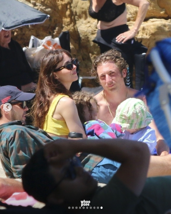 Dakota Johnson and Jeremy Allen White, along with Jeremy's daughters Ezer and Dolores, sit closely together on a crowded Malibu Beach in June 2024. | Source: Instagram/whoopsee.it