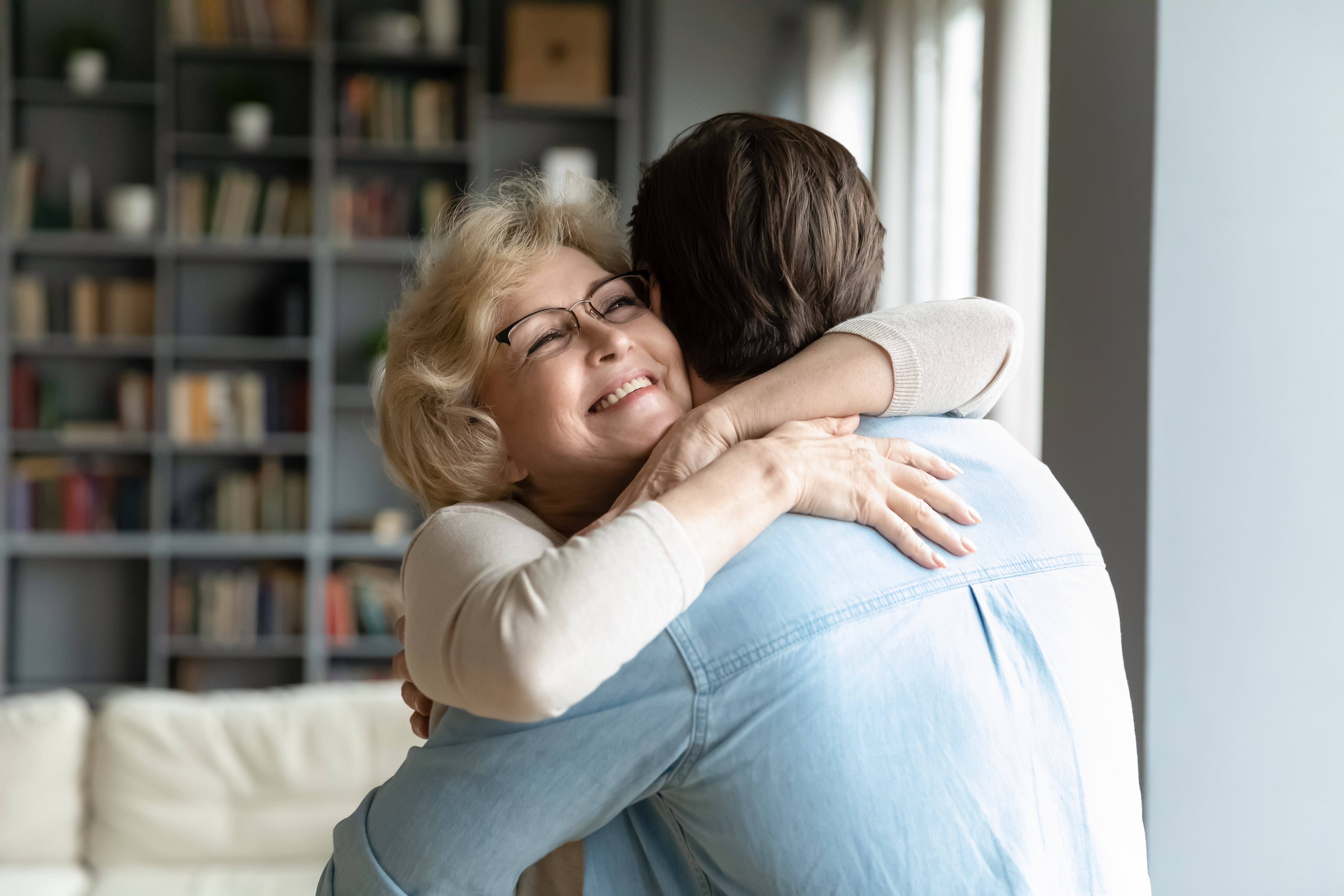 An adult son hugs his older mom | Source: Shutterstock