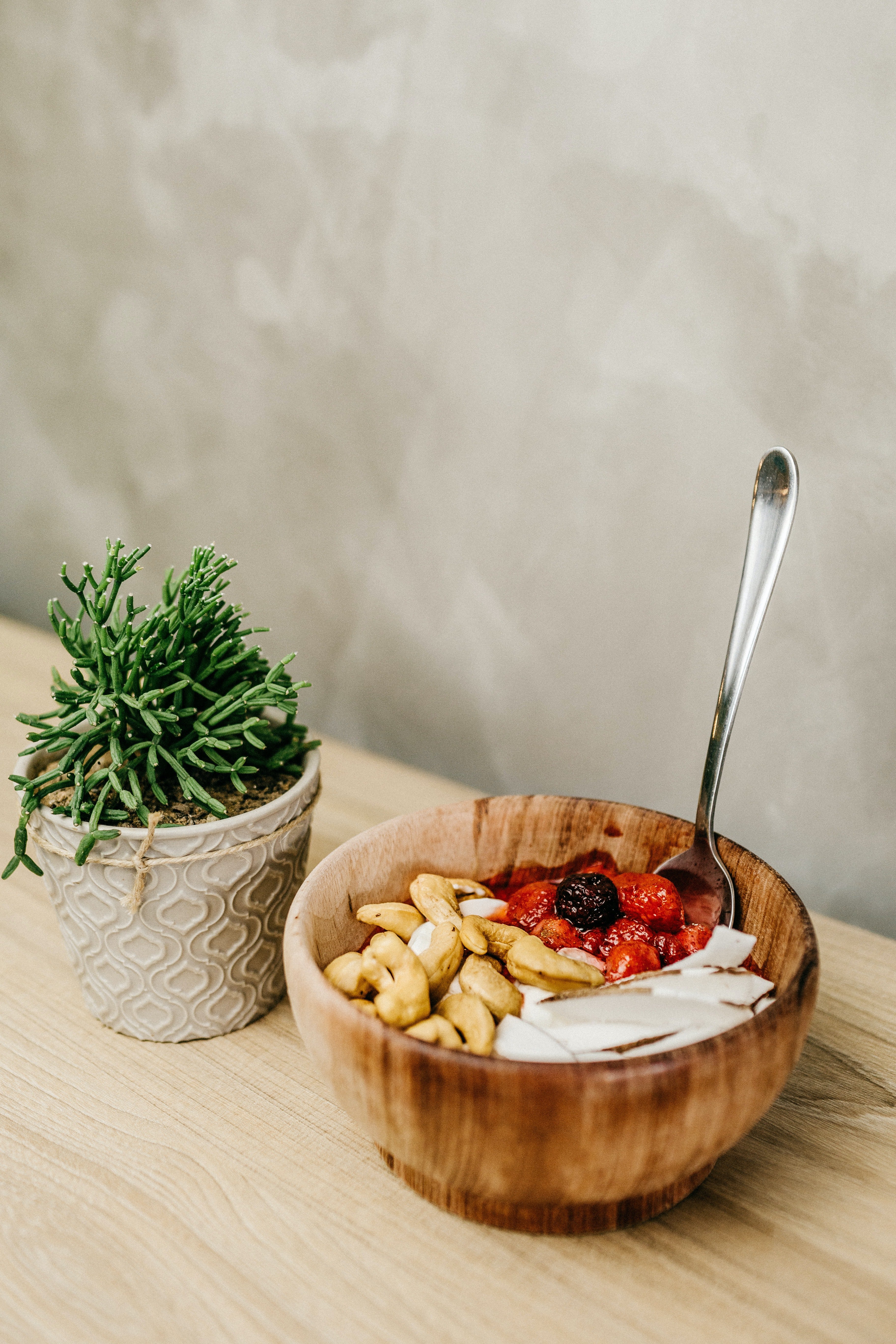 A photo of sliced berries and cashews in a wooden bowl | Source: Pexels 