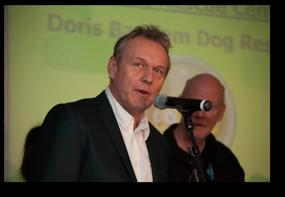 Anthony Head speaks at a Doris Banham Dog Rescue event alongside Paul N. Davis, supporting a cause that was also close to his longtime partner, Sarah Fisher, through her work in animal welfare and training. | Source: Facebook/Doris Banham Dog Rescue
