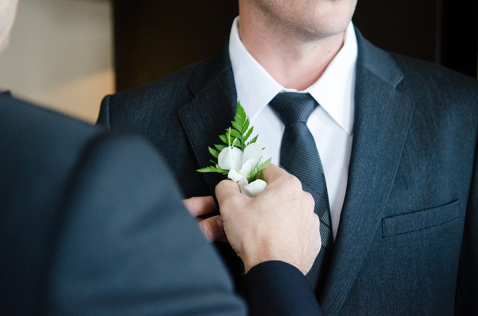 A groom being fixed by one of his groomsmen. | Photo: pixabay.com