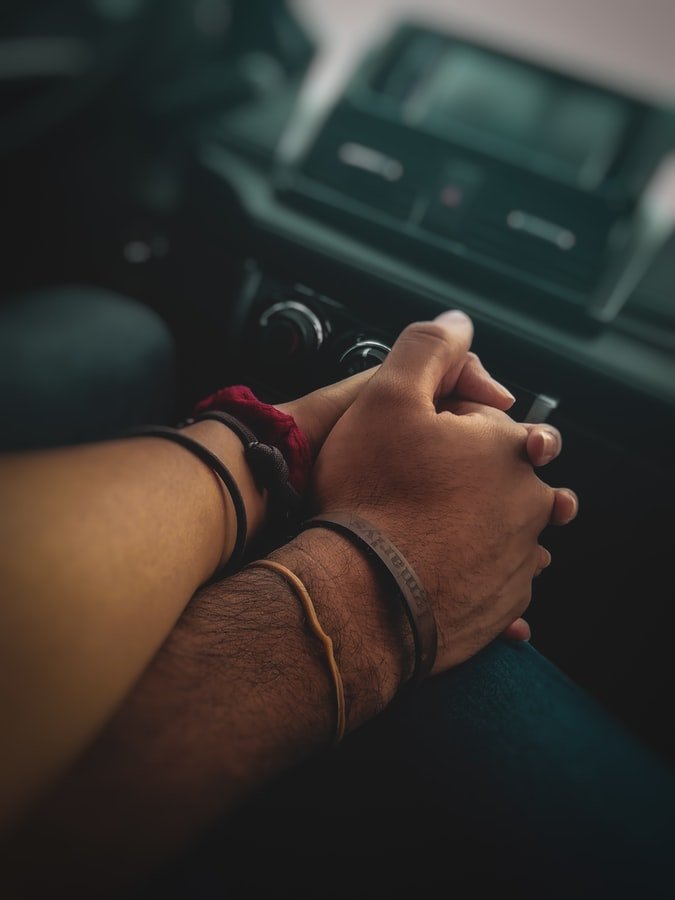 Couple holding hands in a car | Source: Unsplash
