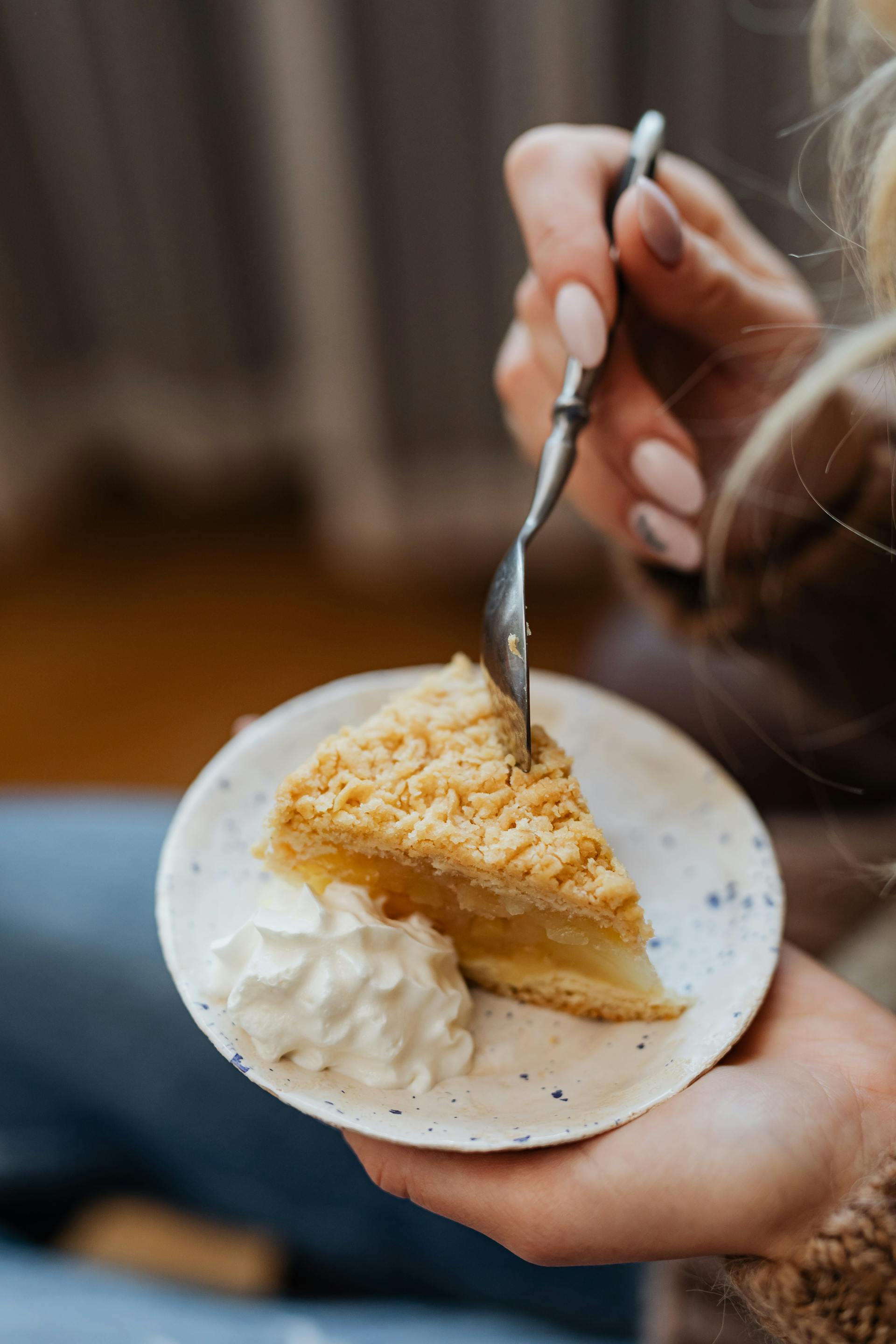 A woman holding a slice of pie | Source: Pexels